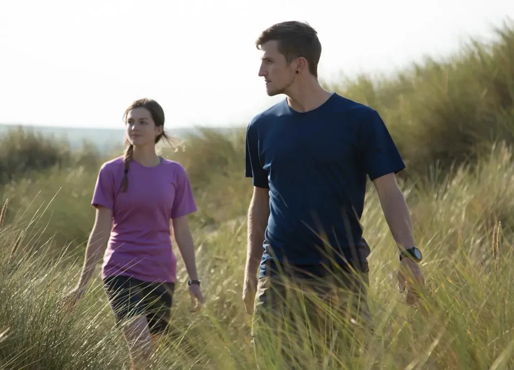 Two walkers in baselayers in long grass