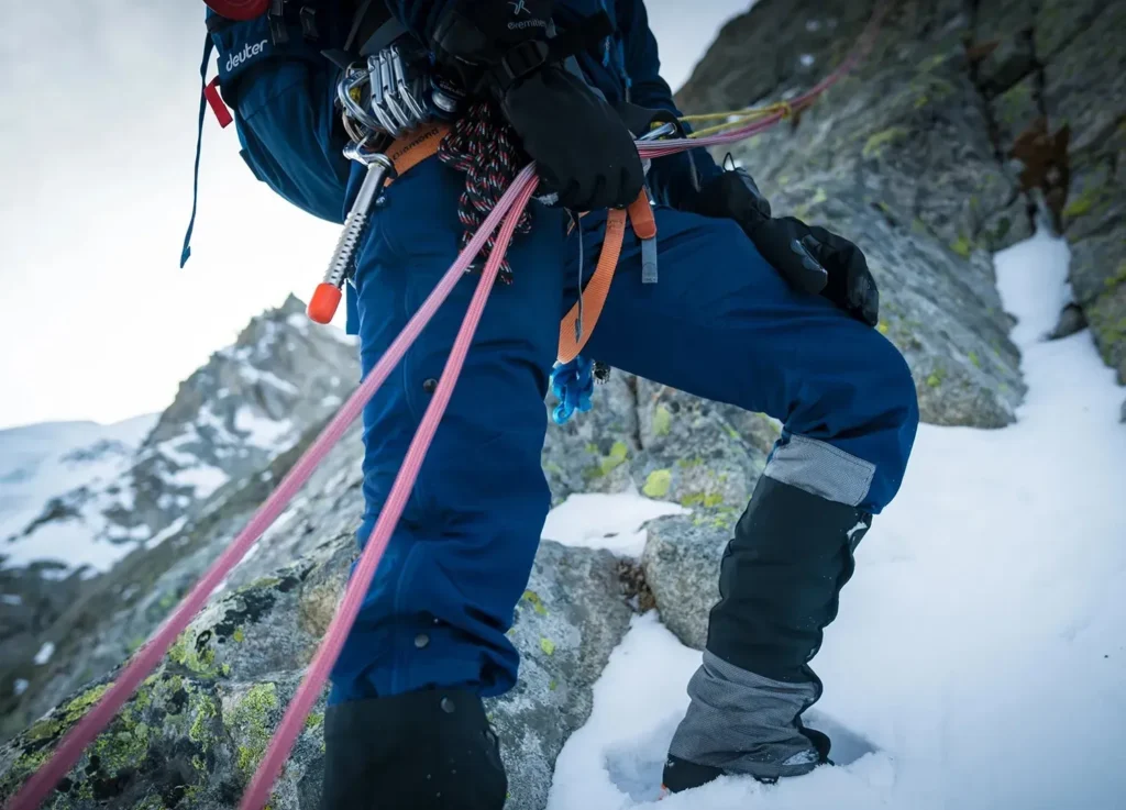 Climber in blue Páramo trousers on a snowy ridge